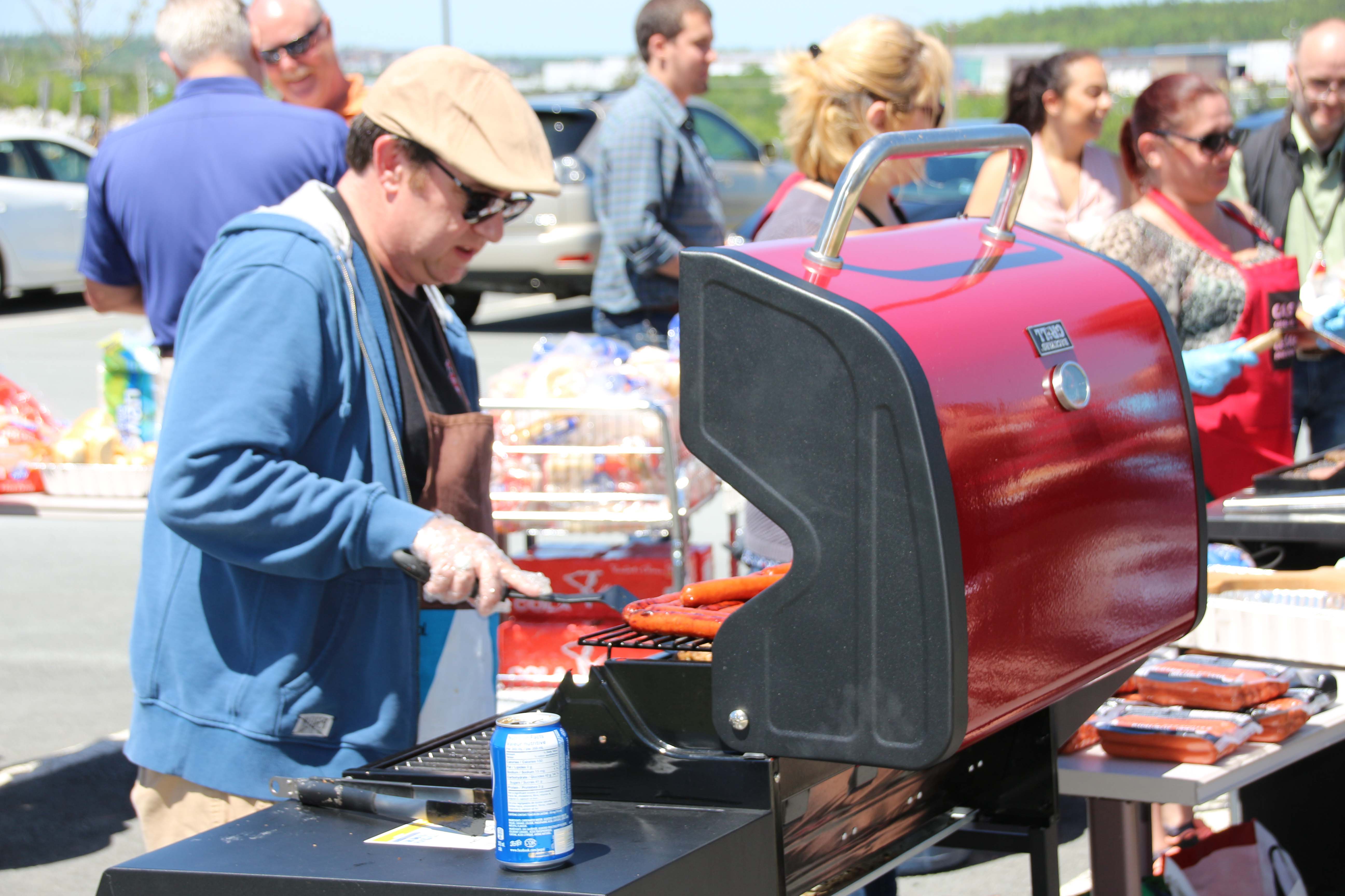 Exec on grills (Darryl Payne, Barb Burns-Bahadur, Cheryl Ballard) with RVP in background on bun duty