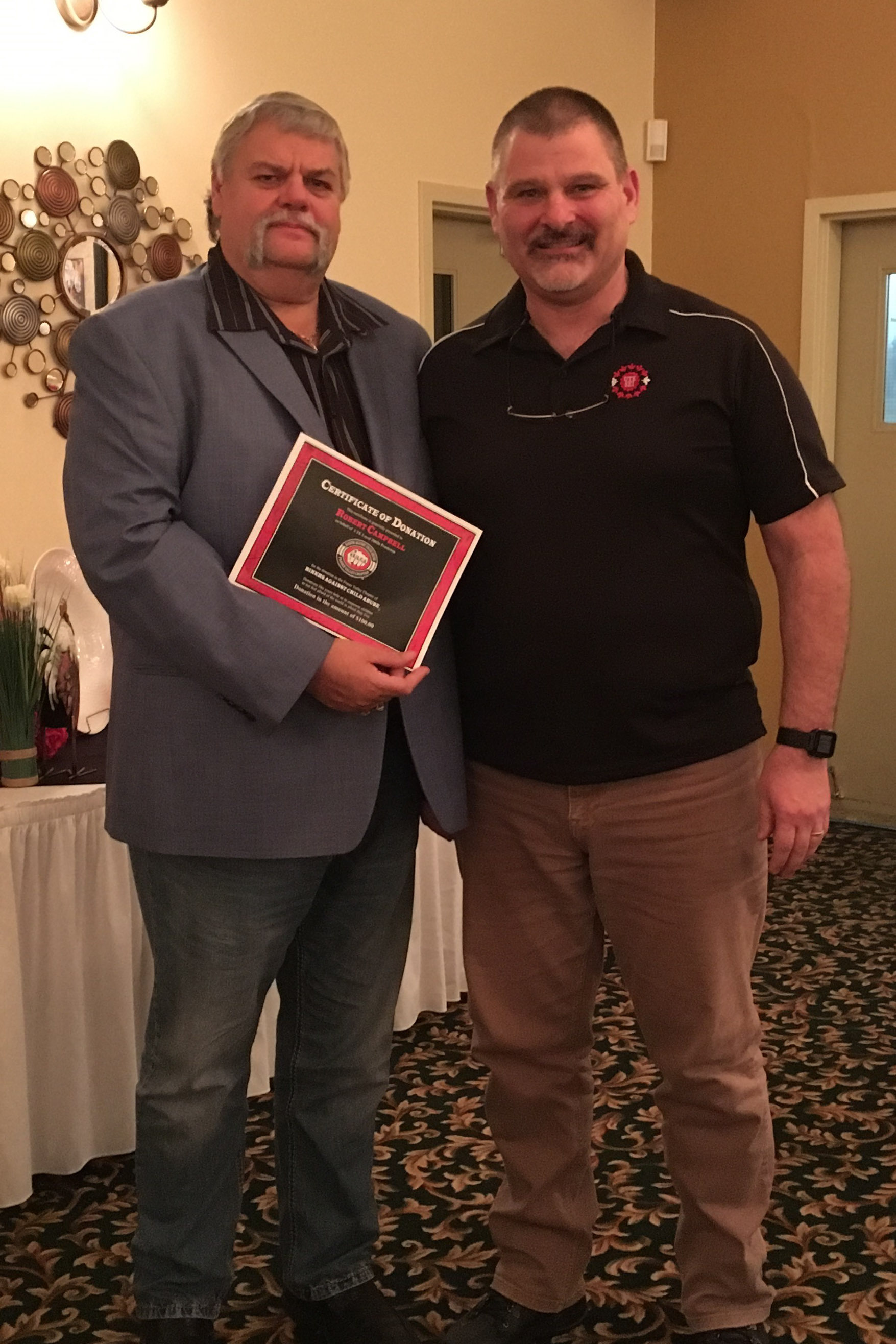 Bob Campbell receiving the donation certificate from Local President Derek Johannson